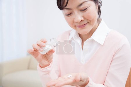 Téléchargez les photos : Gros plan asiatique femme prise médecine pilule - en image libre de droit