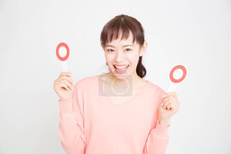 Photo for Young woman showing red circle signs. Japanese girl with OK placards - Royalty Free Image