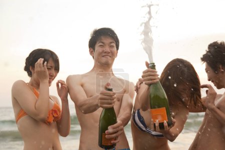 Téléchargez les photos : Jeunes amis asiatiques s'amuser et ouvrir champagne - en image libre de droit