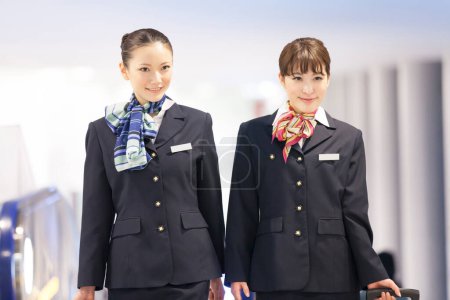 Photo for Two beautiful Japanese flight attendants in airport - Royalty Free Image