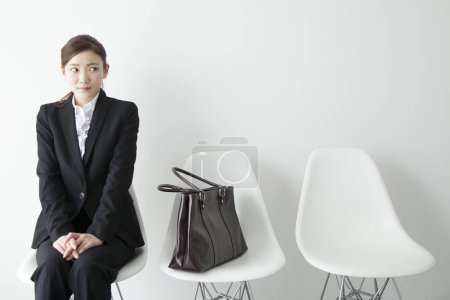 Téléchargez les photos : Jeune femme d'affaires assise sur une chaise - en image libre de droit