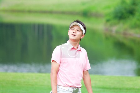 Téléchargez les photos : Asiatique homme jouer golf sur golf terrain - en image libre de droit