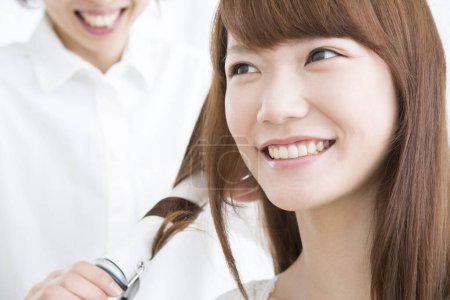 Téléchargez les photos : Jeune femme se faire boucler les cheveux dans le salon de beauté - en image libre de droit