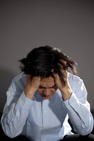 Foto de Estresado asiático hombre sentado, depresión y ansiedad - Imagen libre de derechos