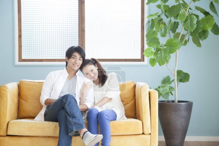 Téléchargez les photos : Jeune couple relaxant au canapé - en image libre de droit