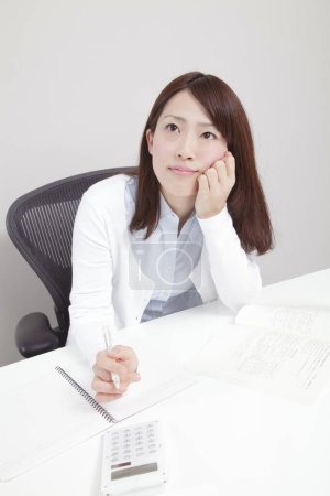 Foto de Mujer joven que trabaja en el escritorio en la oficina - Imagen libre de derechos