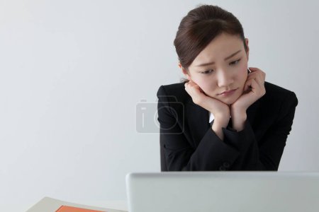 Téléchargez les photos : Portrait de jeune femme d'affaires japonaise triste avec ordinateur portable - en image libre de droit