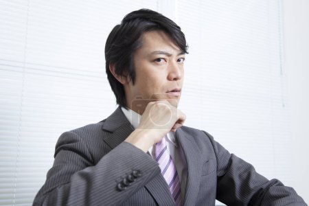 Téléchargez les photos : Portrait d'homme d'affaires japonais en costume isolé sur blanc - en image libre de droit