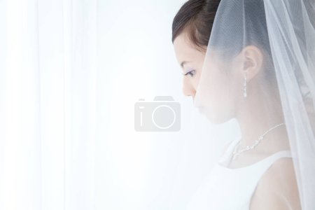 Téléchargez les photos : Une femme en robe de mariée regardant vers le bas - en image libre de droit