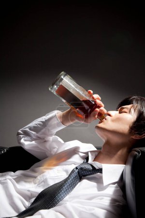 Foto de Joven bebiendo whisky de la botella - Imagen libre de derechos