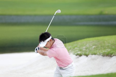 Téléchargez les photos : Asiatique golfeur frapper balle de golf - en image libre de droit