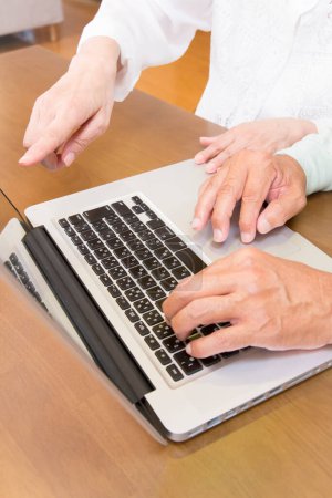Téléchargez les photos : Gros plan des mains des femmes et des hommes à l'aide d'un ordinateur portable - en image libre de droit