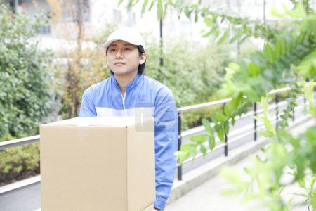 Photo for Young man delivery man in uniform with boxes - Royalty Free Image