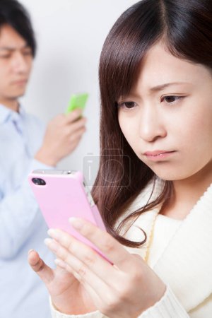 Téléchargez les photos : Jeune couple asiatique avec smartphones - en image libre de droit