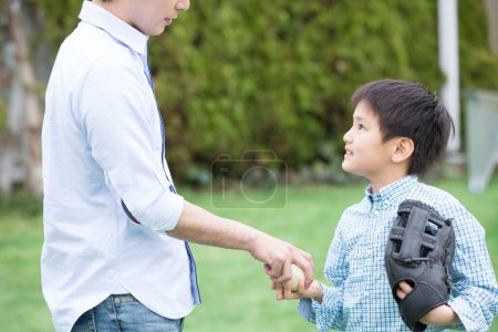 Photo for Father and son playing  baseball on lawn - Royalty Free Image