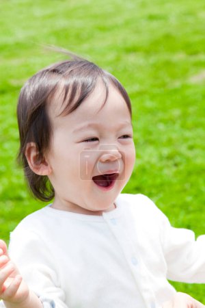 Photo for Cute little japanese child playing in summer park - Royalty Free Image