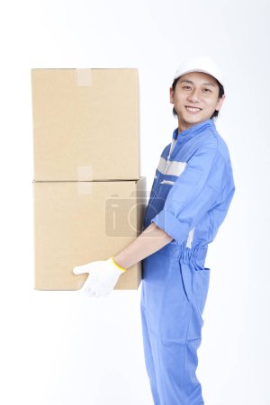 Foto de Hombre en azul uniforme celebración de cajas de cartón - Imagen libre de derechos
