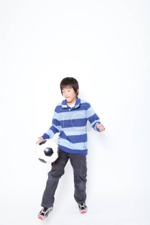 Téléchargez les photos : Portrait de jeune asiatique garçon avec ballon de football - en image libre de droit