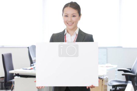 Photo for Business woman holding blank banner in offfice - Royalty Free Image