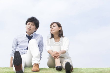 Téléchargez les photos : Portrait d'un jeune homme et d'une femme assis sur la pelouse - en image libre de droit
