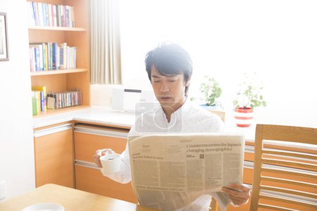 Foto de Joven leyendo el periódico y tomando café - Imagen libre de derechos
