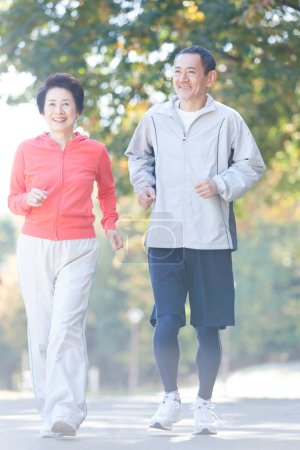 Foto de Asiático senior pareja jogging en parque - Imagen libre de derechos