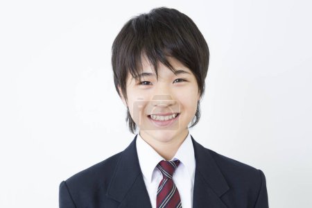 Portrait of Japanese teenager in uniform standing on white studio background 