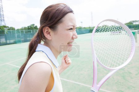 Photo for Portrait of woman holding racket on court - Royalty Free Image