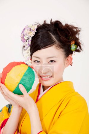 Photo for Woman wearing traditional japanese kimono with a colorful ball - Royalty Free Image