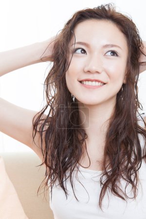 Téléchargez les photos : Jeune femme avec de longs cheveux bruns et un fond blanc - en image libre de droit