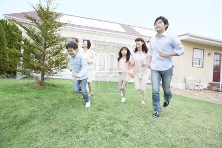 Foto de Retrato de gran familia japonesa corriendo cerca de casa - Imagen libre de derechos