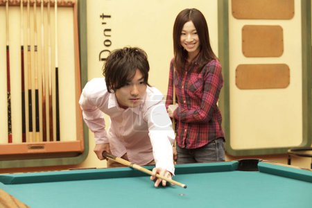 Foto de Feliz japonés joven hombre y mujer jugando al billar - Imagen libre de derechos