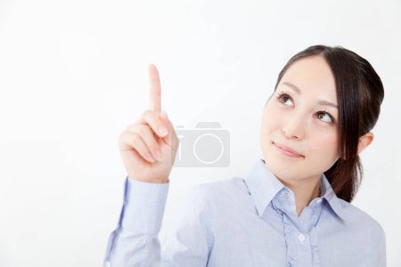 Téléchargez les photos : Jeune femme d'affaires pointant vers le haut, plan studio - en image libre de droit