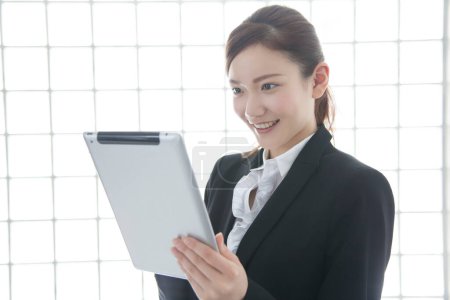 Téléchargez les photos : Jeune femme d'affaires tenant une tablette en fonction - en image libre de droit