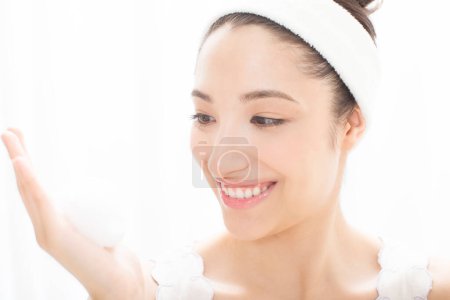 Photo for Japanese woman cleaning face, closeup portrait of young lady washing her face - Royalty Free Image