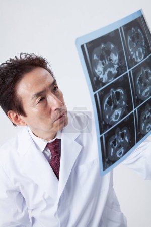 Foto de Asiático sénior asiático médico holding cerebro scan - Imagen libre de derechos