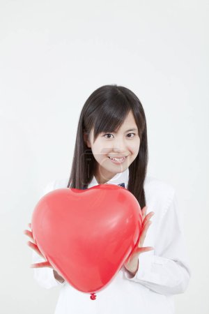 Téléchargez les photos : Portrait de asiatique étudiant tenant coeur rouge - en image libre de droit
