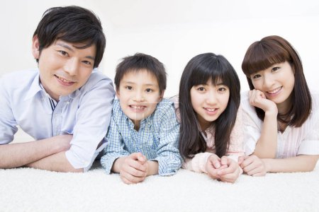 Téléchargez les photos : Portrait de heureux japonais famille posant à la maison - en image libre de droit