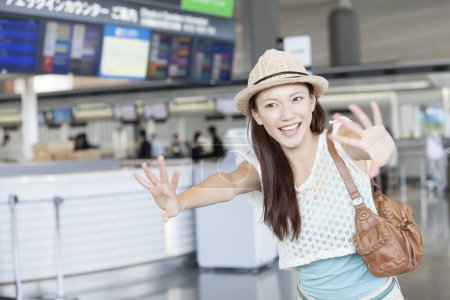 Foto de Una mujer en un sombrero posando para una foto en el aeropuerto - Imagen libre de derechos