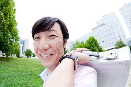 Téléchargez les photos : Heureux asiatique homme avec mallette dans l 'parc - en image libre de droit