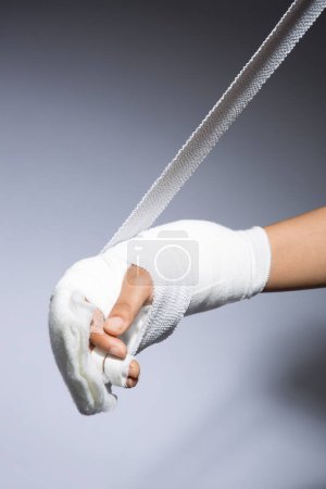 Foto de Vendaje de mano femenina sobre fondo gris, vista de cerca - Imagen libre de derechos