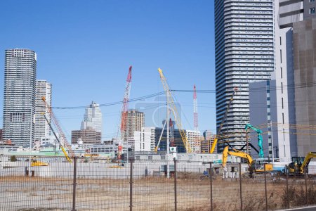 Téléchargez les photos : Vue diurne des grues côté construction dans la ville japonaise - en image libre de droit