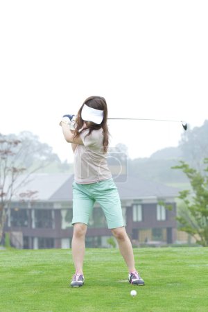 Téléchargez les photos : Femme jouant au golf dans le parcours - en image libre de droit