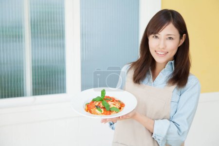Photo for Smiling woman holding plate with pasta - Royalty Free Image
