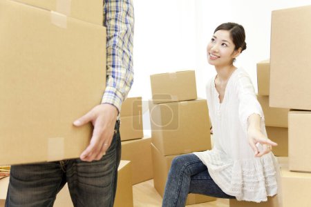 Photo for Asian couple with cardboard boxes moving in new house - Royalty Free Image