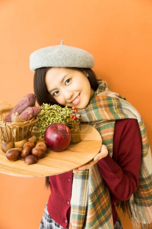 Photo for Close up asian girl holding wooden board with vegetables - Royalty Free Image