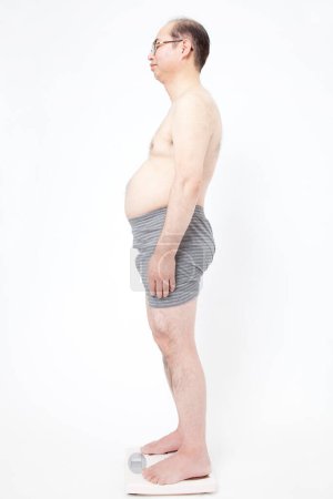 Photo for Japanese fat man in underwear shows fat deposits in abdomen. Concept of not proper nutrition, sedentary lifestyle - Royalty Free Image