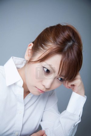 Photo for Portrait of young bored asian businesswoman on light grey background - Royalty Free Image