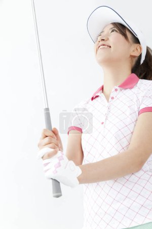 Téléchargez les photos : Belle joueuse de golf japonaise avec visière blanche et club de golf - en image libre de droit