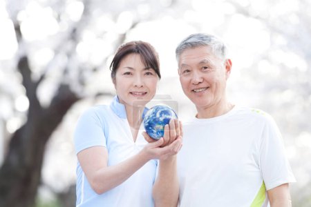 Téléchargez les photos : Mature asiatique couple holding globe - en image libre de droit